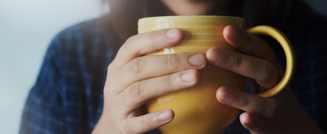 Beautiful woman drinking lemon ginger tea in the morning or cold season