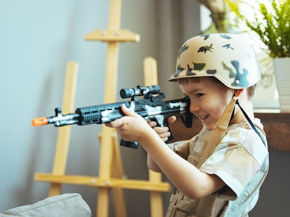Boy Dressed as a Soldier Playing with Plastic Gun