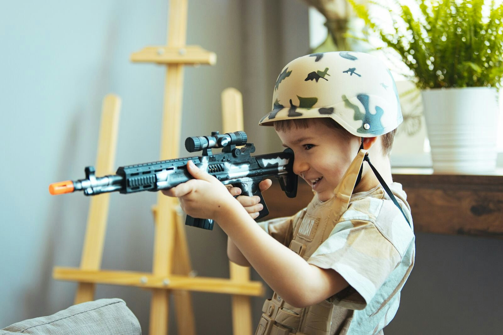 Boy Dressed as a Soldier Playing with Plastic Gun