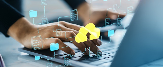 Hands typing on a laptop keyboard with digital icons of folders and a yellow cloud upload symbol, representing cloud data storage and file sharing