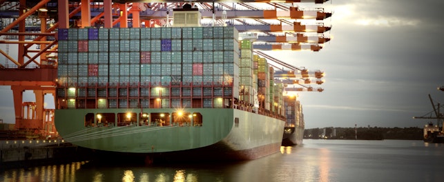 Cargo porte-conteneurs en cours de chargement dans un port industriel.