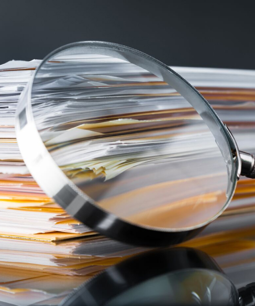 Documents on a Desk and Magnifying Glass