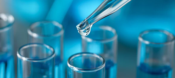 Dripping reagent into test tube against blurred background, closeup