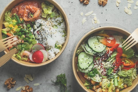 Japans poke bowl with seafood and salad and vegan bowl with vegetables and chickpeas in sustainable food container at grey background. Eco-friendly delivery food with plastic free cutlery. Top view.