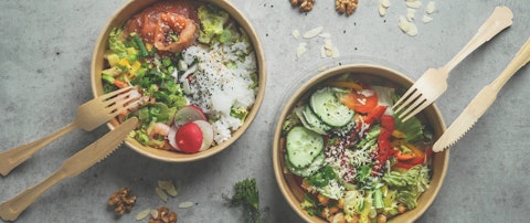 Japans poke bowl with seafood and salad and vegan bowl with vegetables and chickpeas in sustainable food container at grey background. Eco-friendly delivery food with plastic free cutlery. Top view.