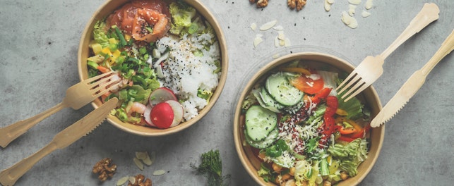 Japans poke bowl with seafood and salad and vegan bowl with vegetables and chickpeas in sustainable food container at grey background. Eco-friendly delivery food with plastic free cutlery. Top view.