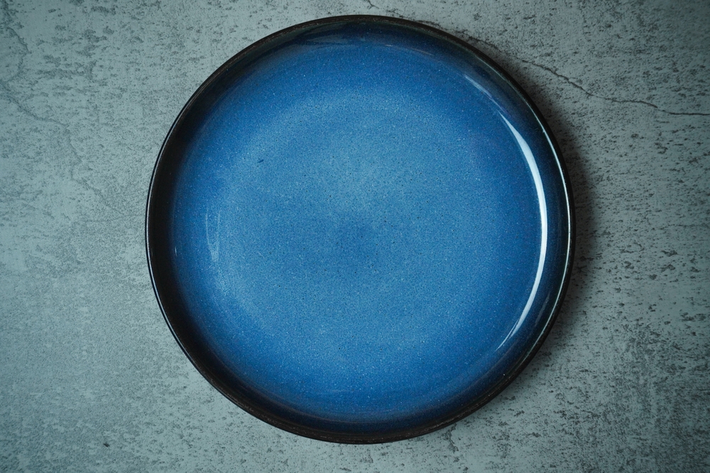 Empty Blue ceramic plate on grey concrete rough background