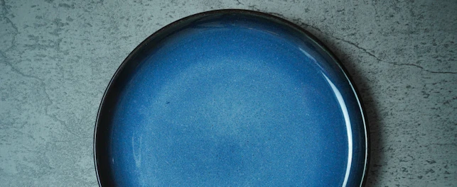 Empty Blue ceramic plate on grey concrete rough background