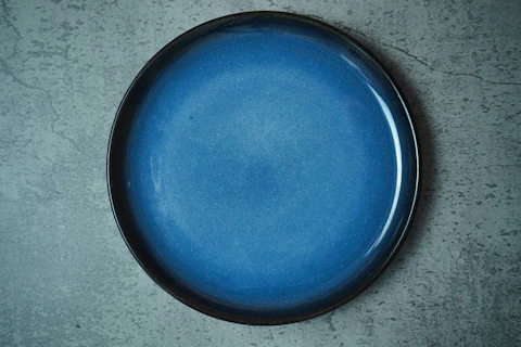 Empty Blue ceramic plate on grey concrete rough background