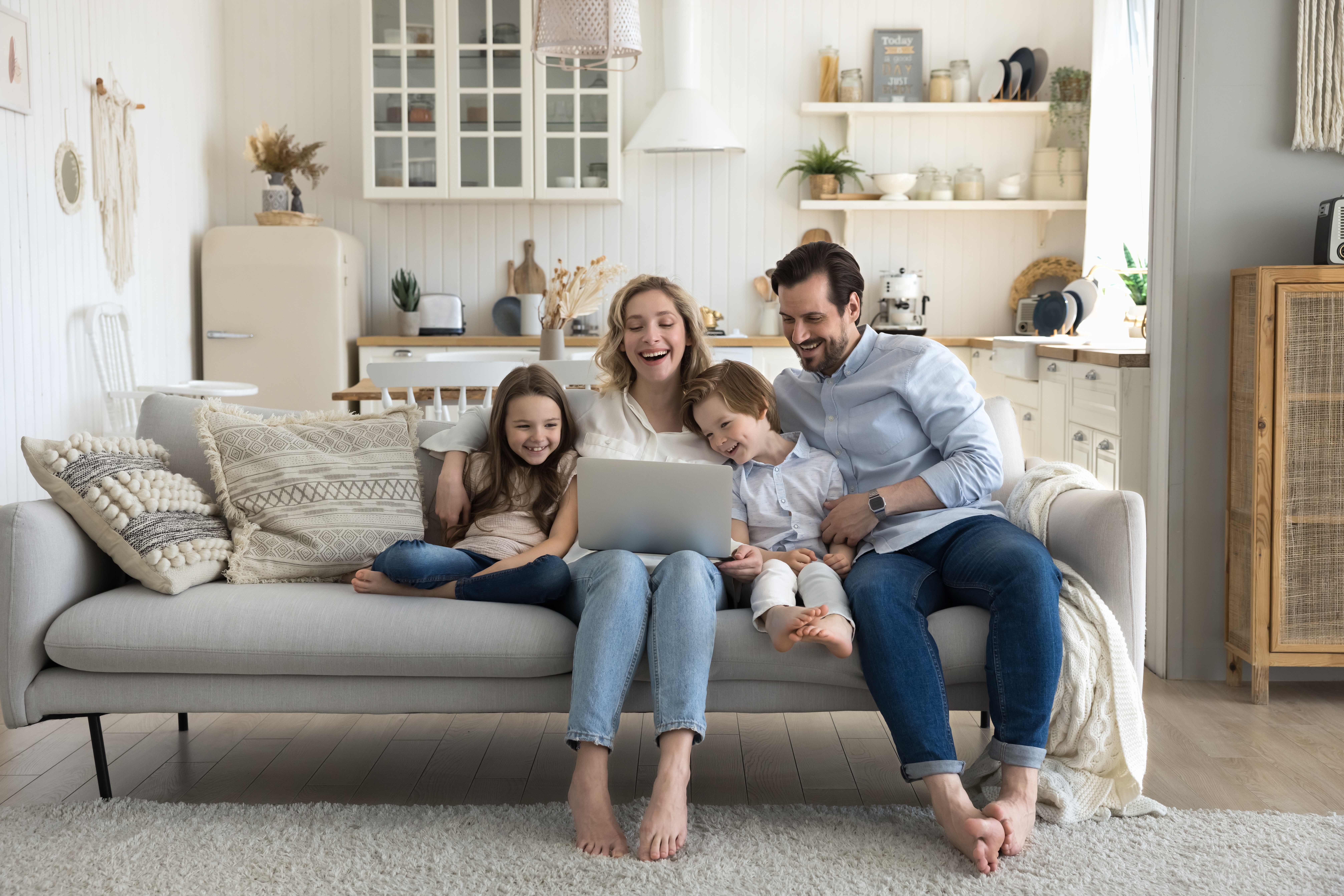 Family using laptop on sofa