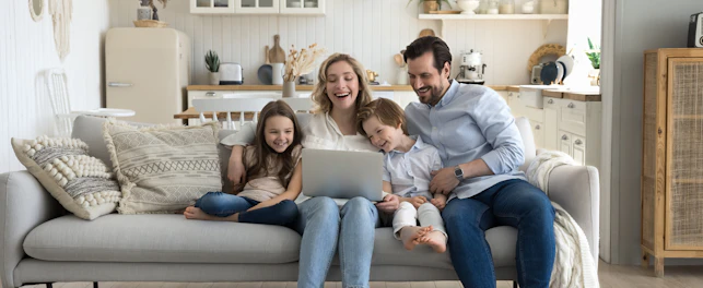 Family using laptop on sofa