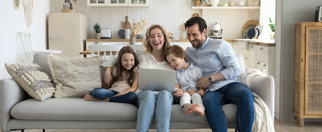 Family using laptop on sofa