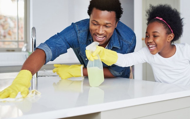 Father and Daughter Cleaning Kitchen Surface