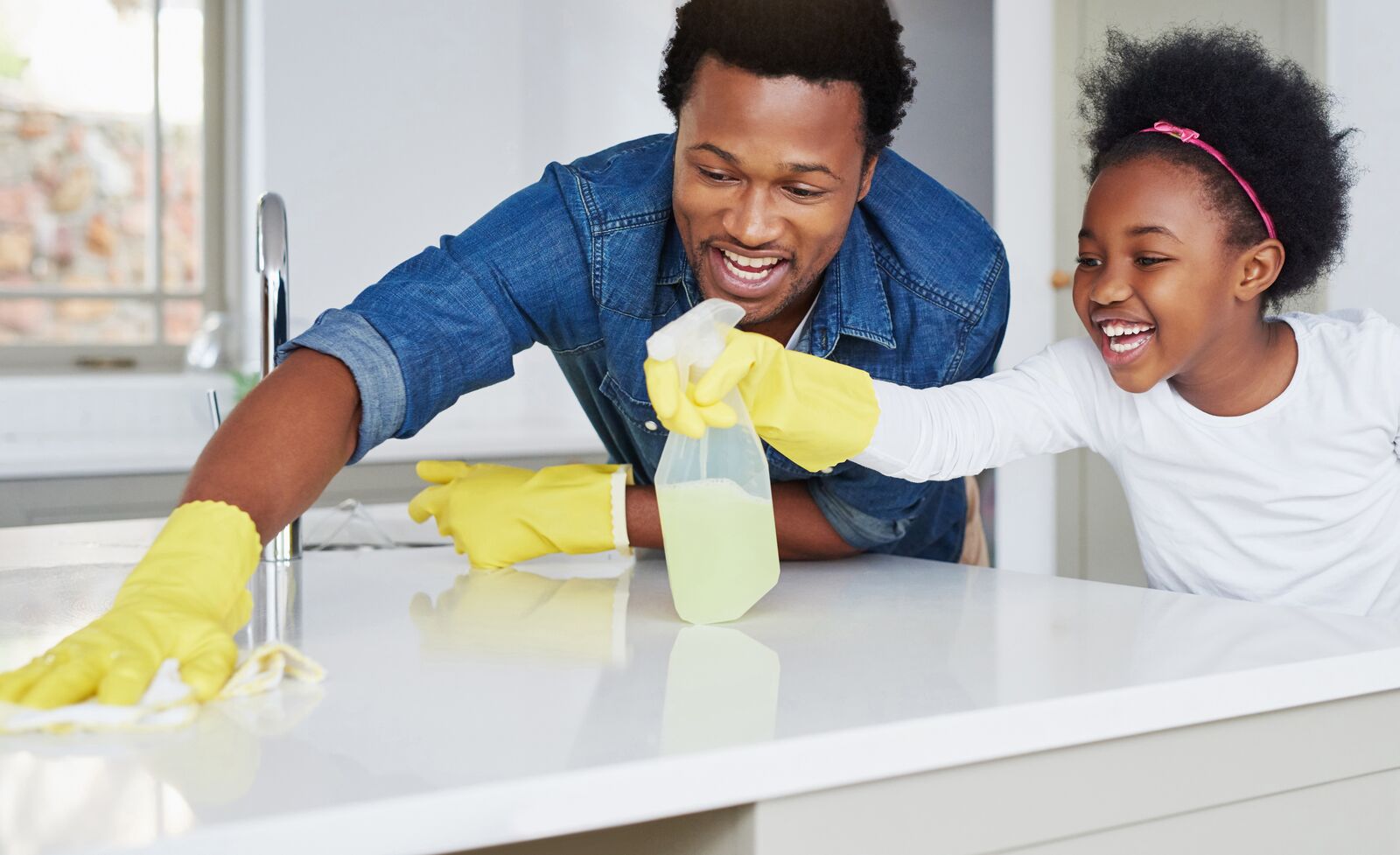 Father and Daughter Cleaning Kitchen Surface