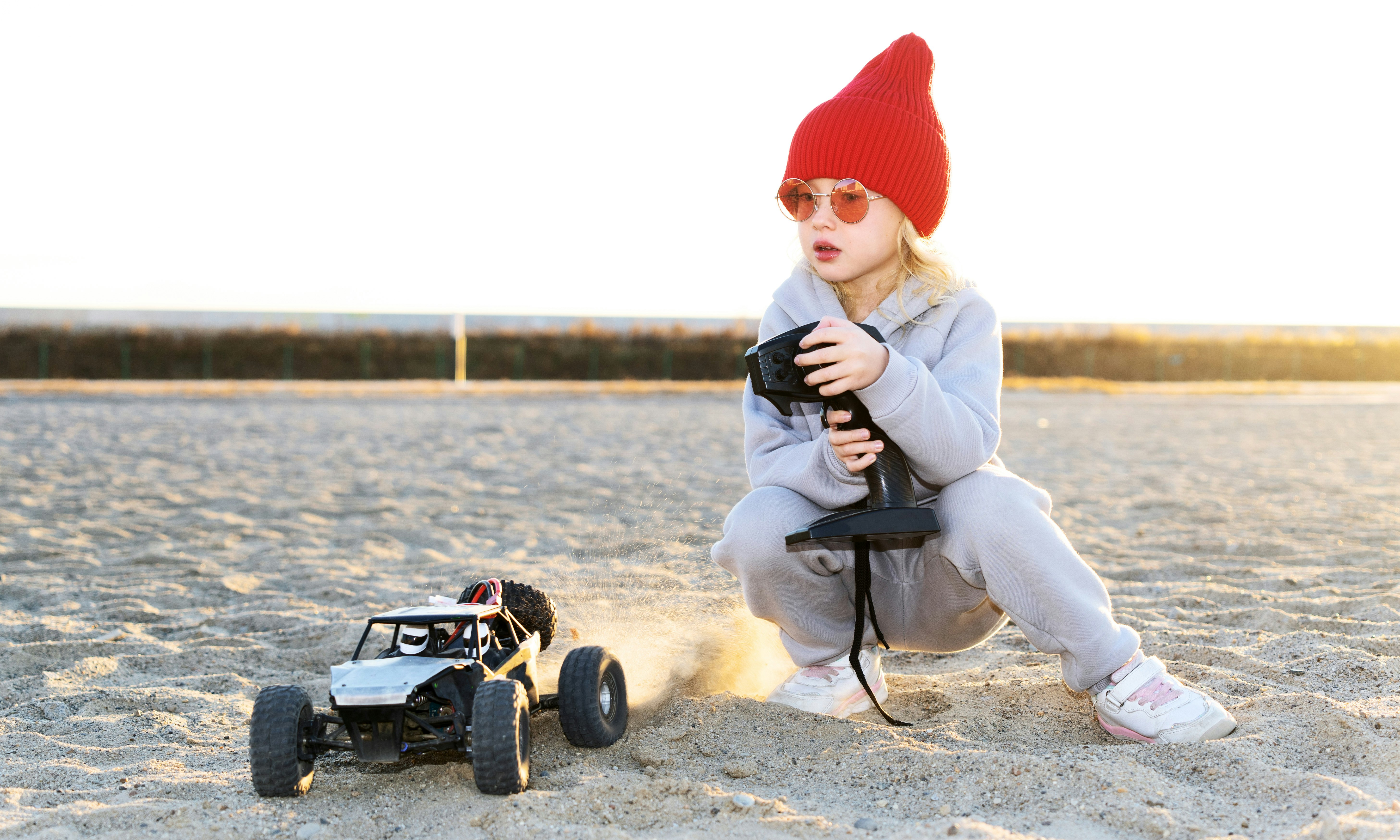Girl Playing with Remote Control Buggy on the Beach