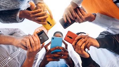  Adolescents en cercle tenant des téléphones portables