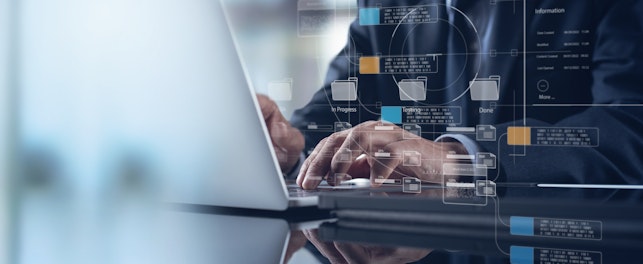 Hands typing on a laptop with transparent digital interface graphics overlaid, representing data management, information systems, or advanced digital workflows.