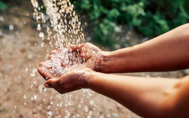 Hands under Stream of Running Water Outdoor