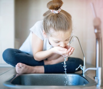 Little Girl Drinking from Water Tap