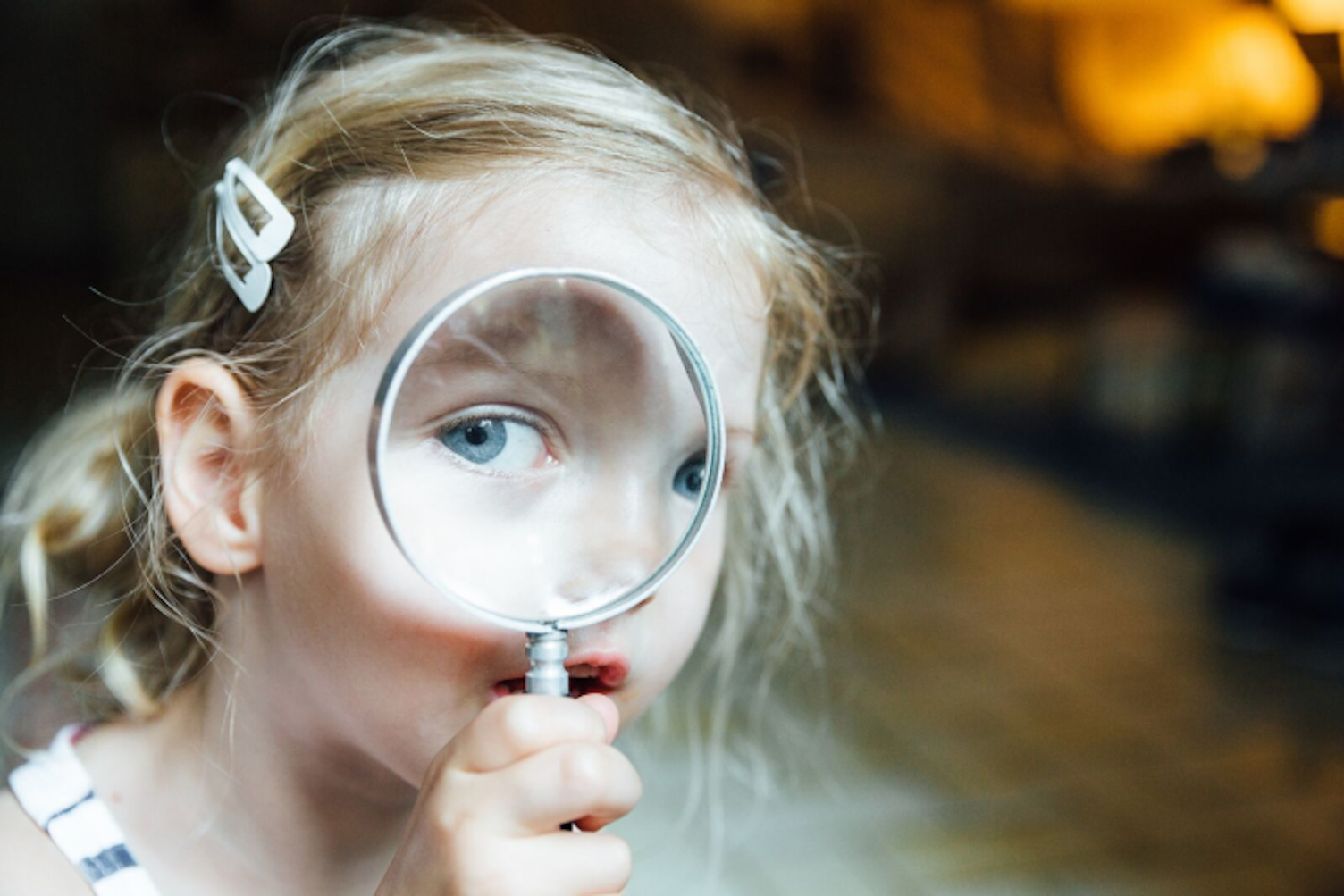 Little Girl Looking through Magnifying Glass