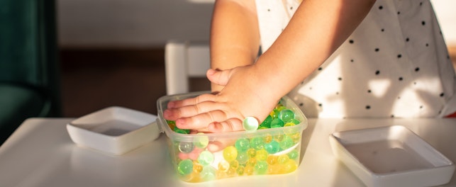 Little girl playing with sensory water beads
