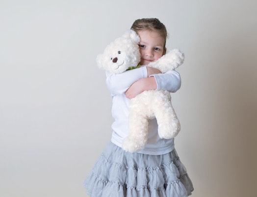 Little Girl Snuggling her Teddy Bear
