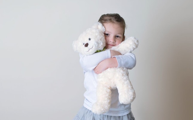 Little Girl Snuggling her Teddy Bear