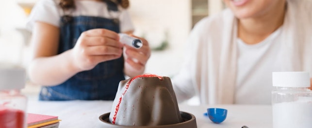 Mother and daughter in protective glasses watching a chemistry experiment