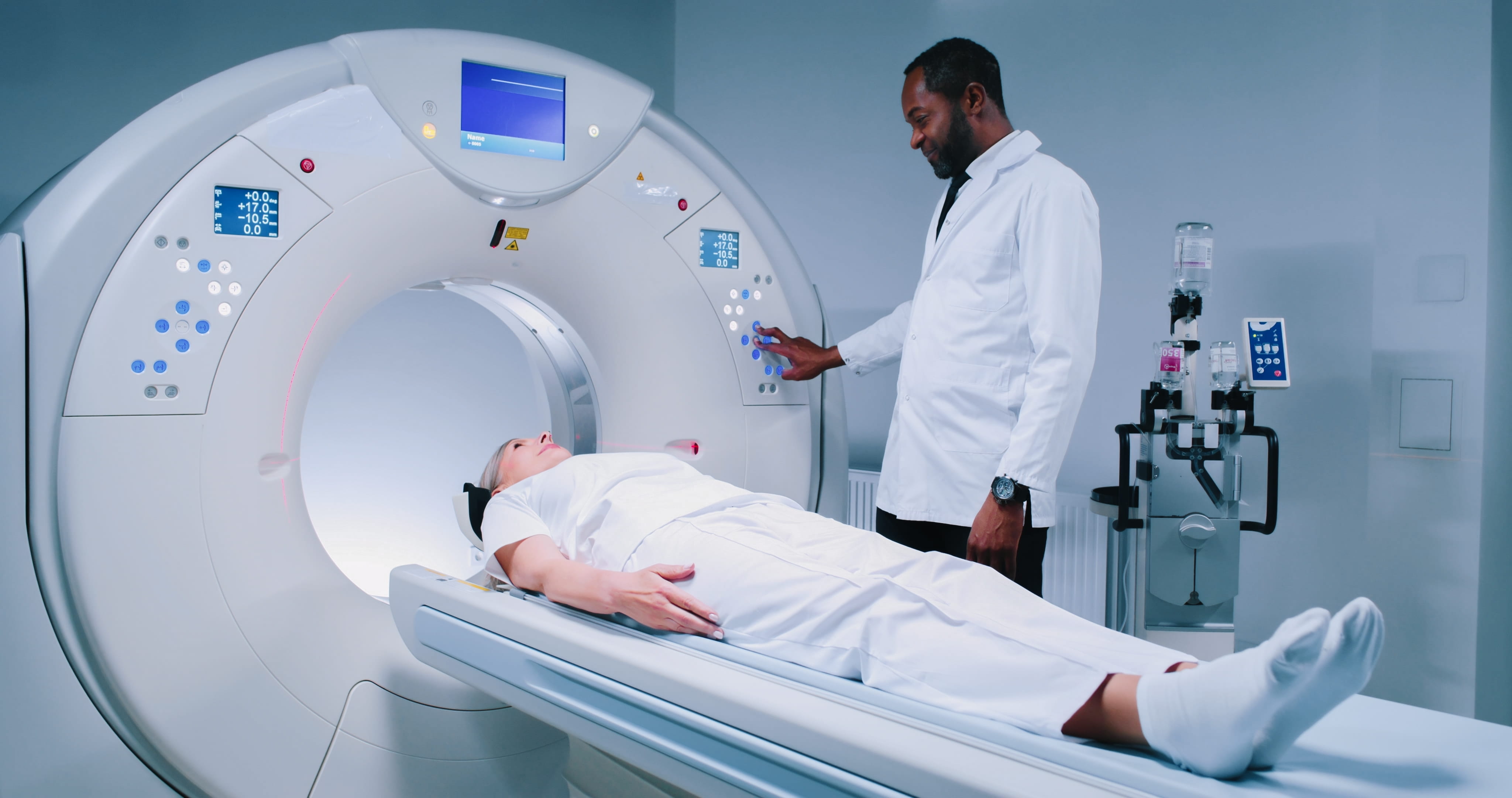 Multicultural Doctor is Pushing Buttons at CT Scanner