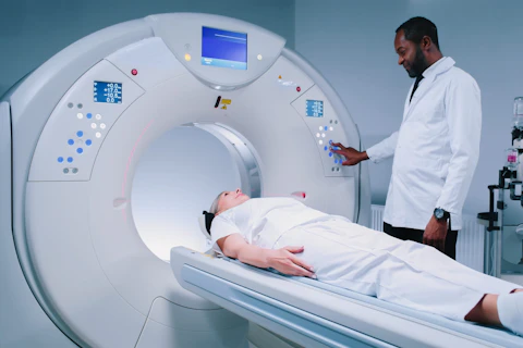 Multicultural Doctor is Pushing Buttons at CT Scanner