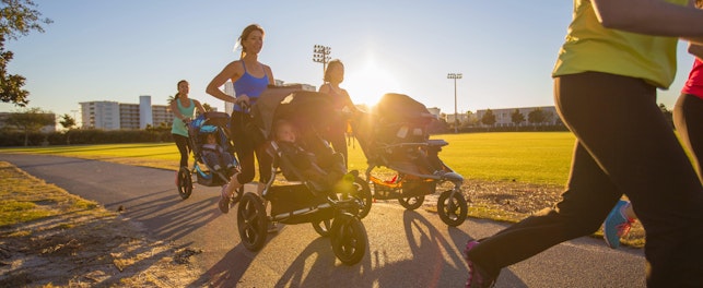 Femmes faisant du jogging avec des poussettes sportives sur une piste extérieure au coucher du soleil.