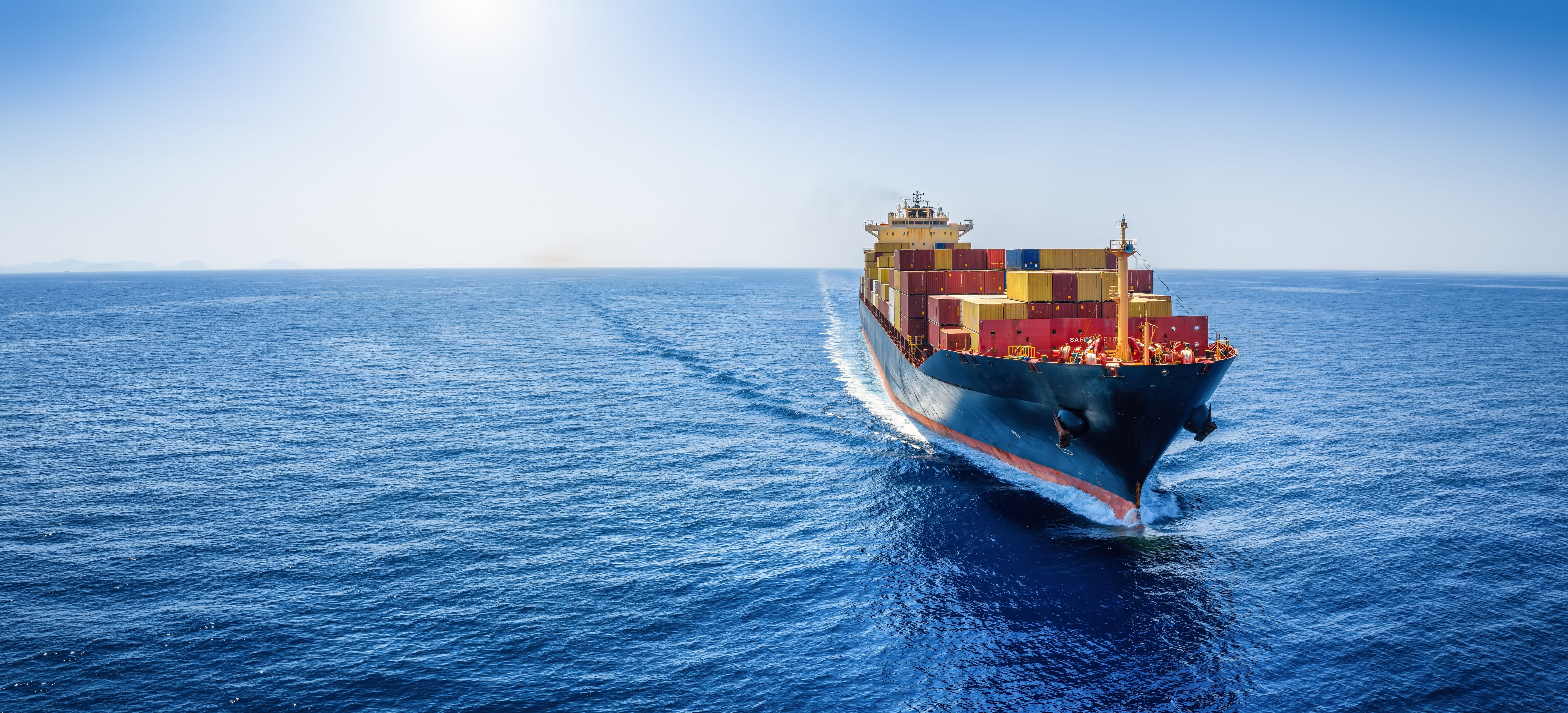 Panoramic front view of a cargo ship carrying containers