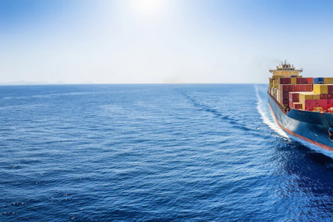 Panoramic front view of a cargo ship carrying containers
