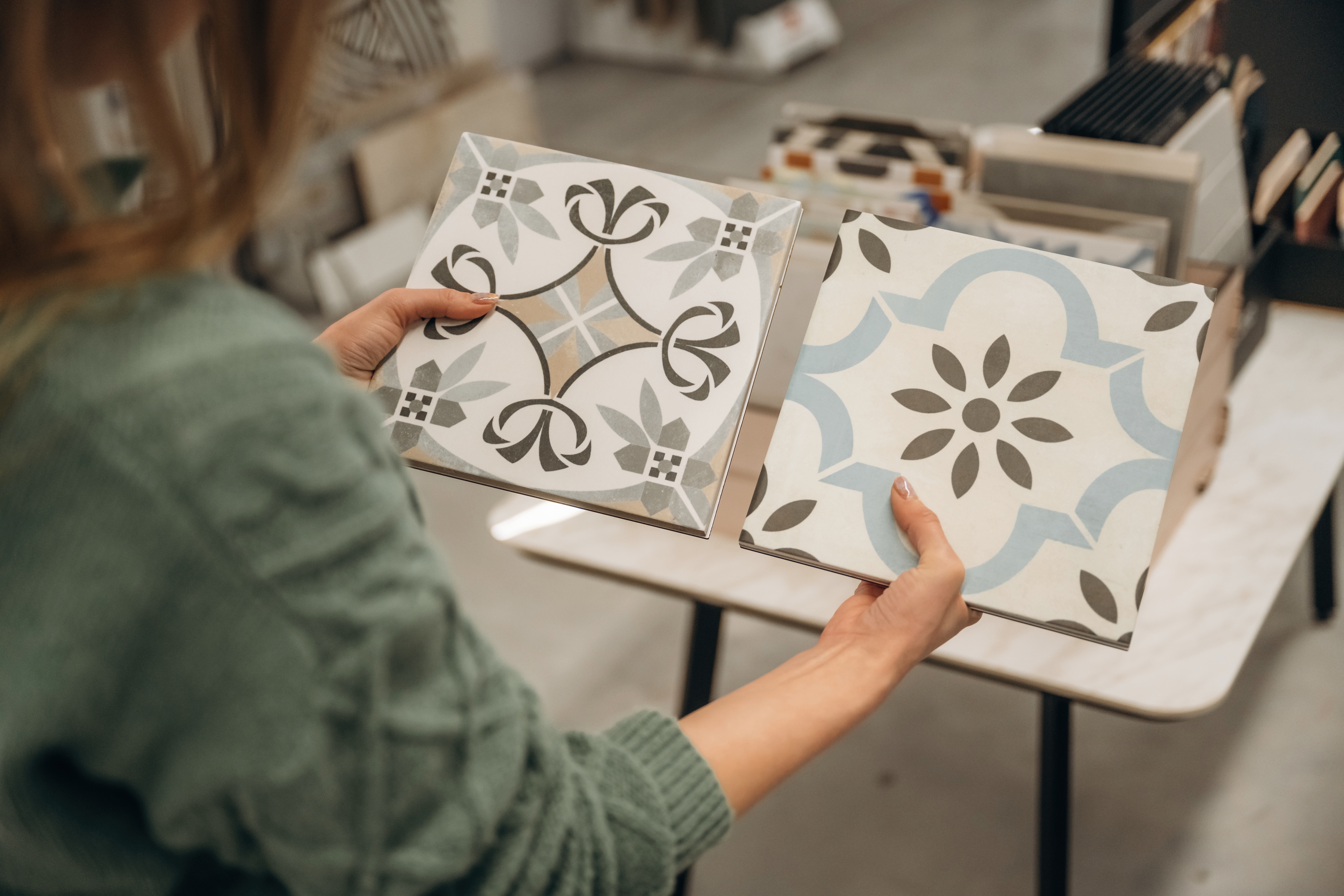 Person holding two ceramic tiles