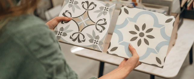 Person holding two ceramic tiles