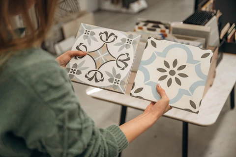 Person holding two ceramic tiles
