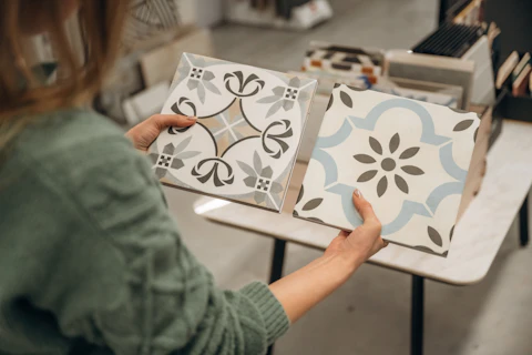 Person holding two ceramic tiles