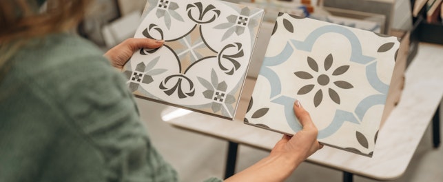 Person holding two ceramic tiles
