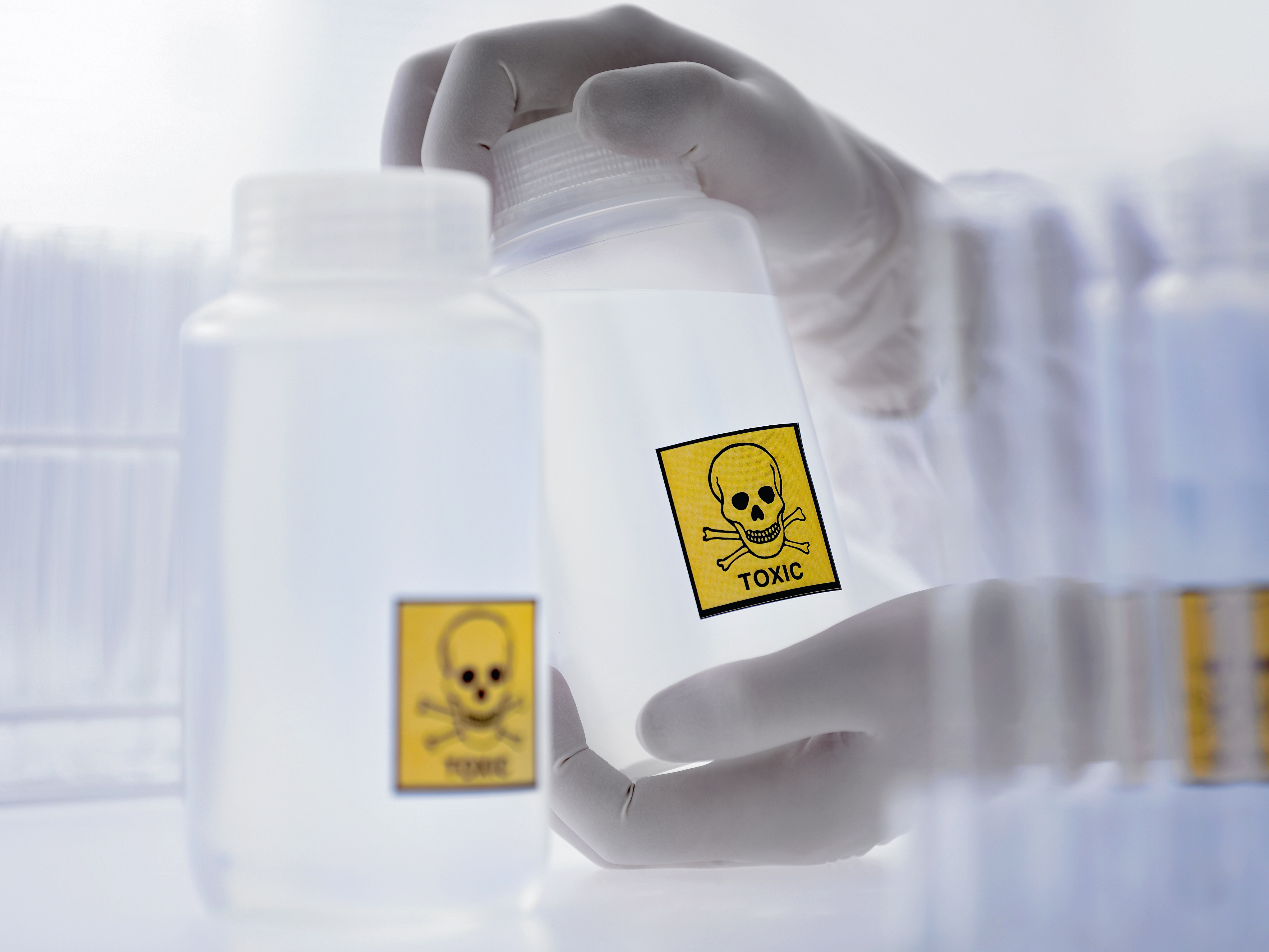 Scientist Holding Bottle with Toxic Label