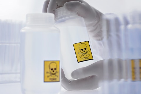 Scientist Holding Bottle with Toxic Label