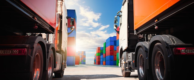 Semi trailer Trucks on The Parking Lot with Stacked Containers