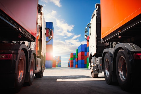 Semi trailer Trucks on The Parking Lot with Stacked Containers