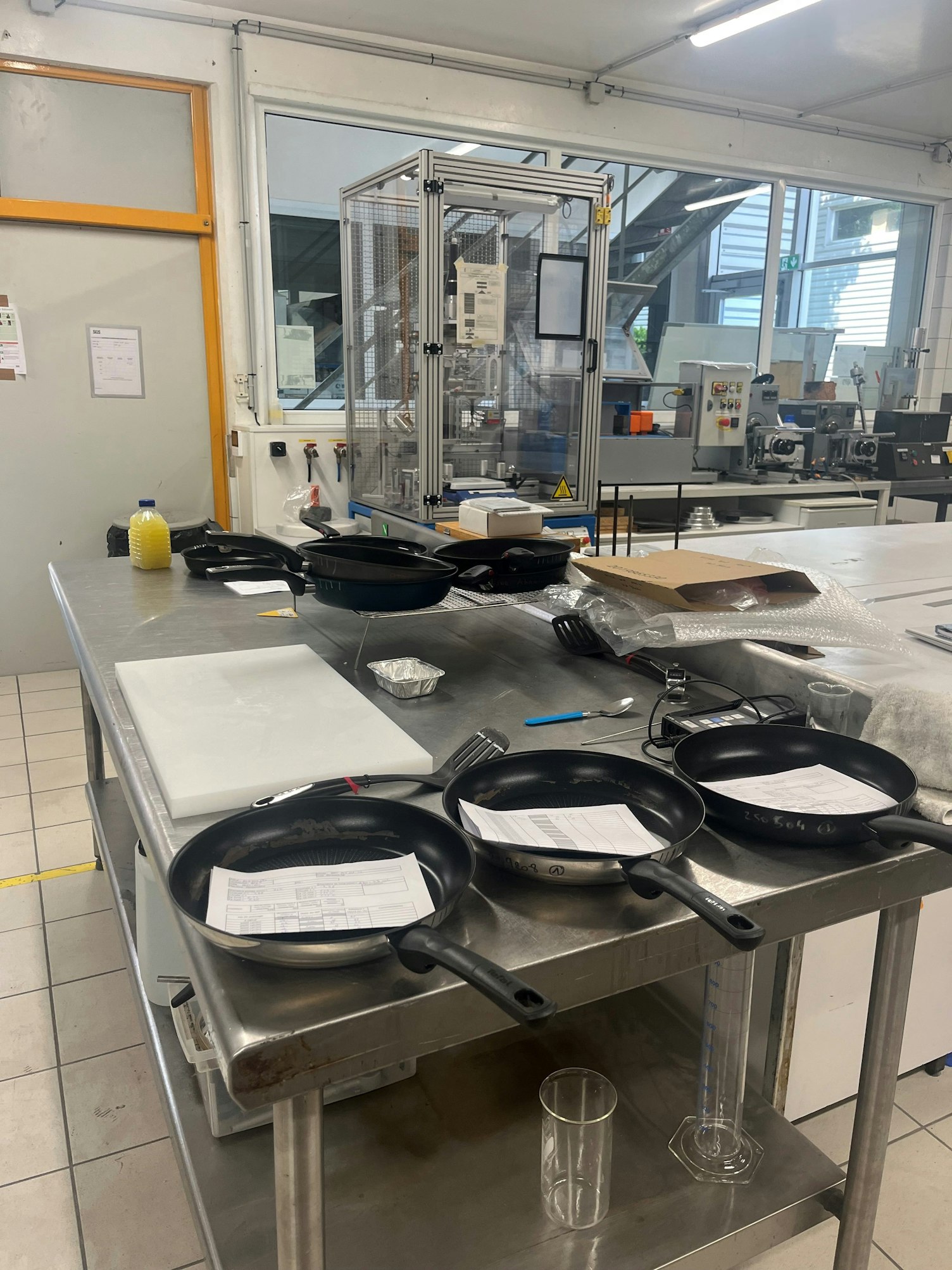 Laboratoire d’essai avec poêles posées sur table inox chez SGS Cestas