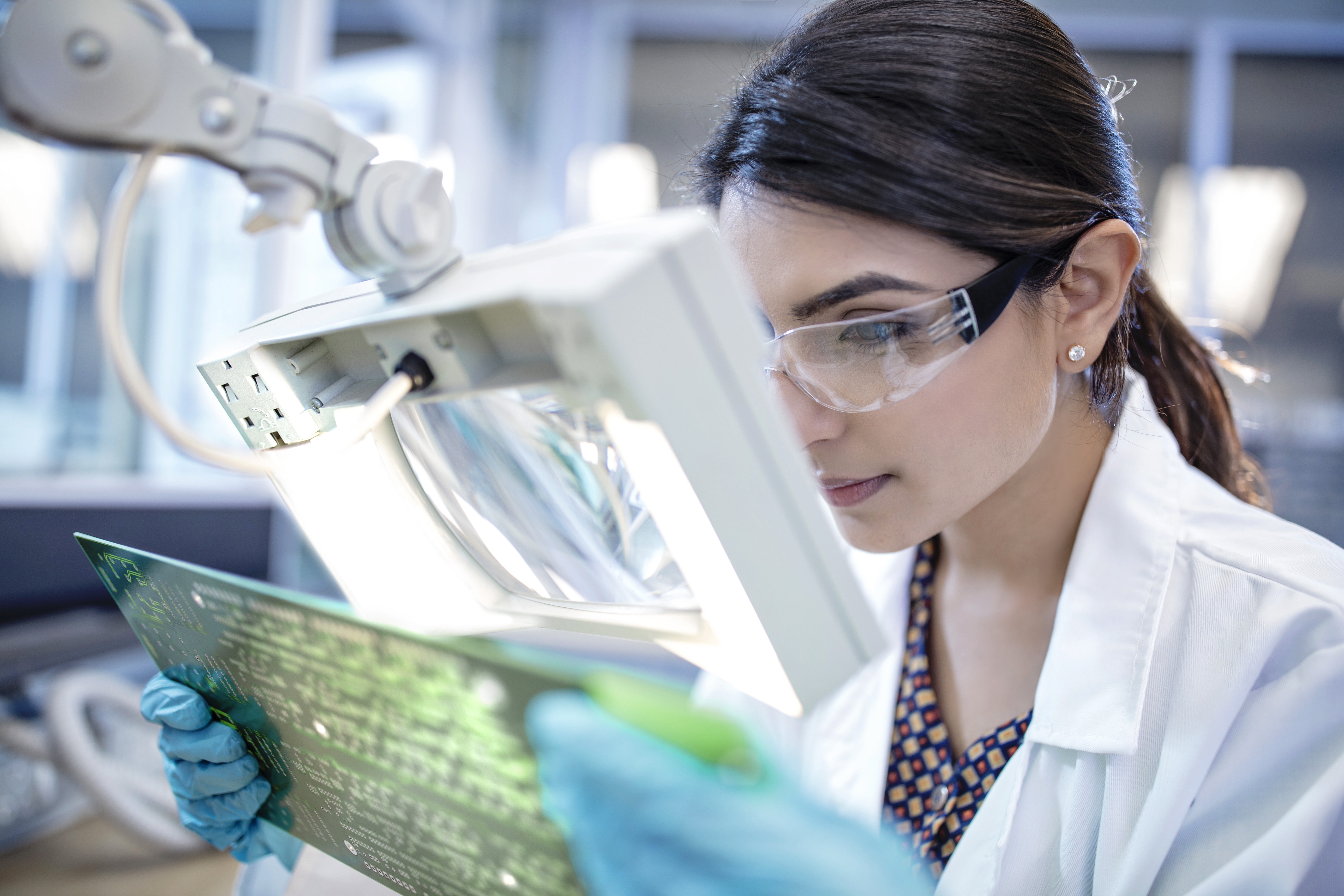 Technician in Laboratory Examining Motherboard