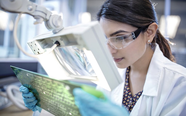 Technician in Laboratory Examining Motherboard