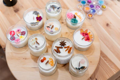Variety of natural soy candles prepared during a workshop, decorated with dried flowers, herbs, and spices