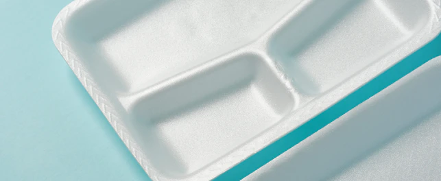 white Styrofoam plastic plates on blue background