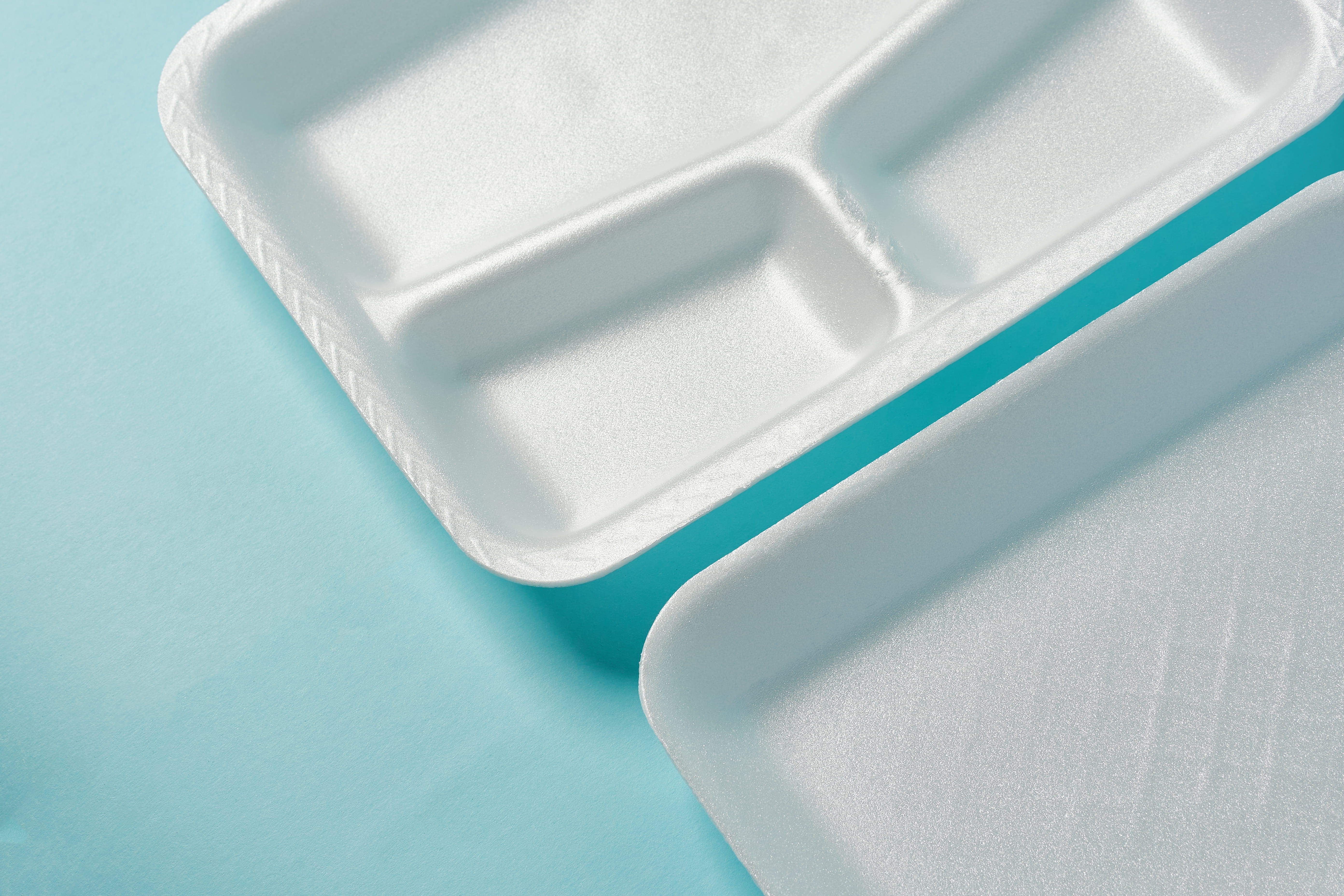 white Styrofoam plastic plates on blue background
