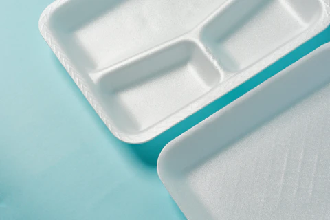 white Styrofoam plastic plates on blue background