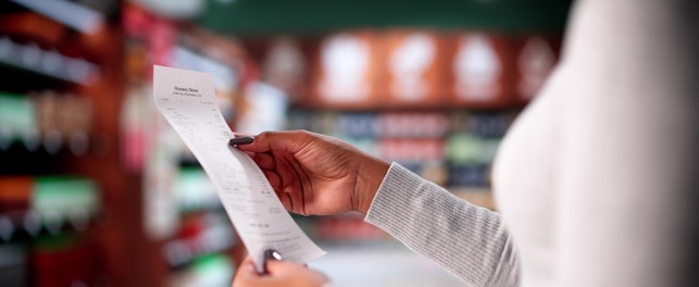 Woman Checking Grocery Store Receipt After Shopping At Supermarket